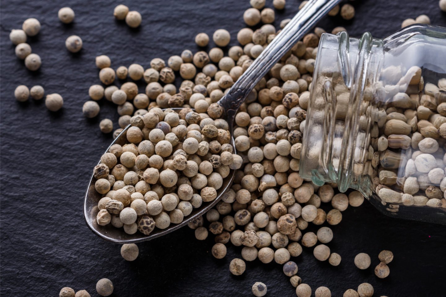 White Peppercorns In Spoon On Dark Background