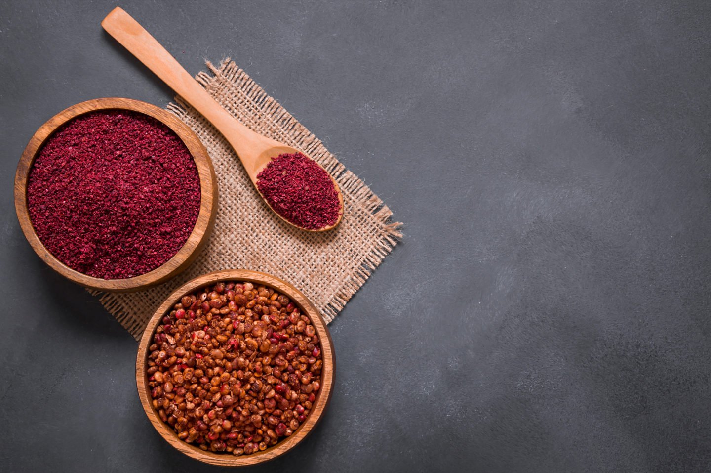 Whole And Ground Sumac In Wooden Bowls