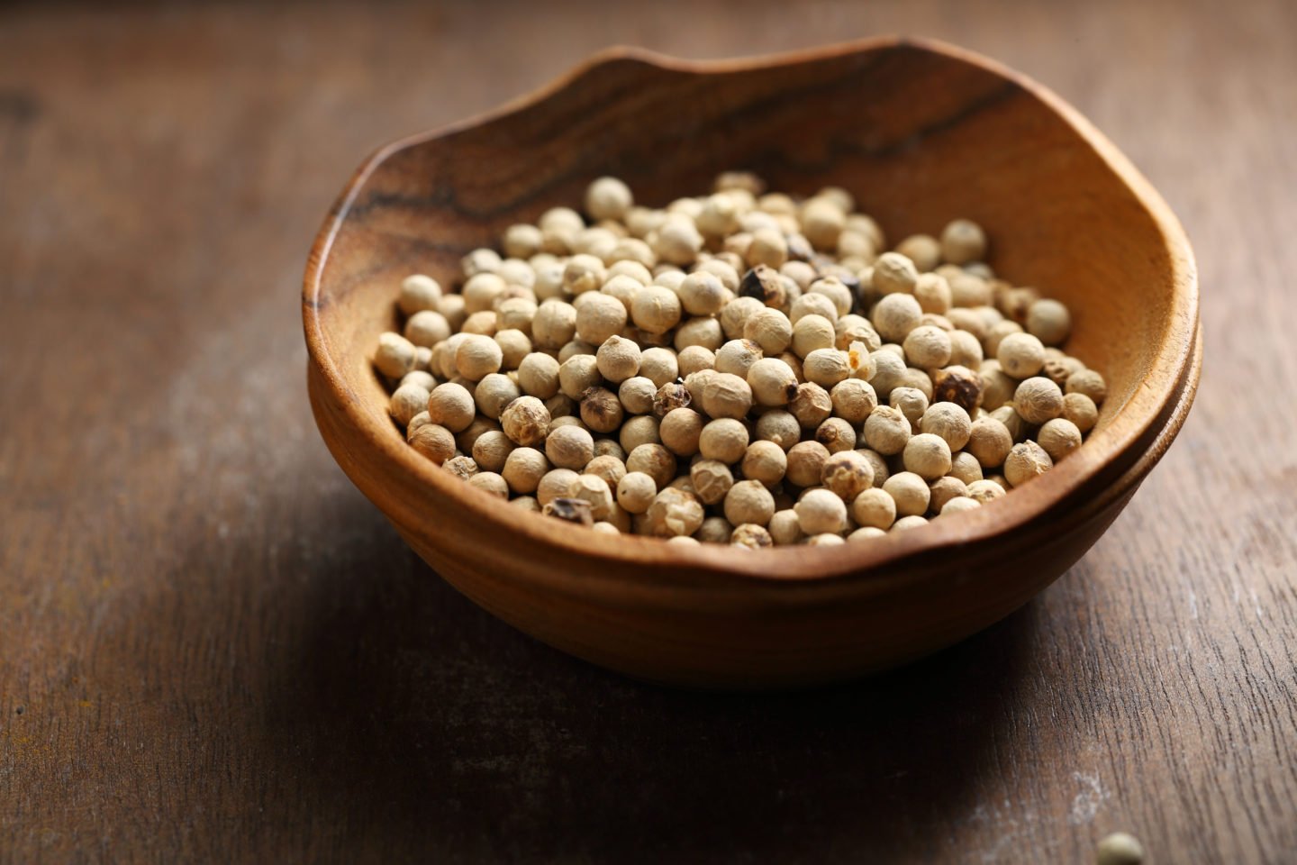 Whole White Peppercorns In Wooden Bowl