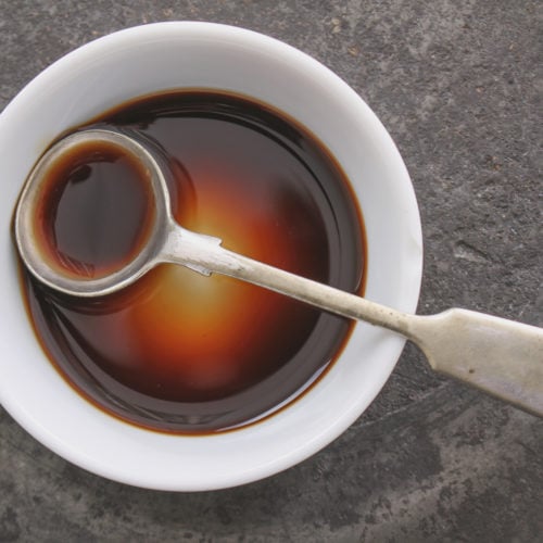 worcestershire sauce in shallow white bowl with spoon