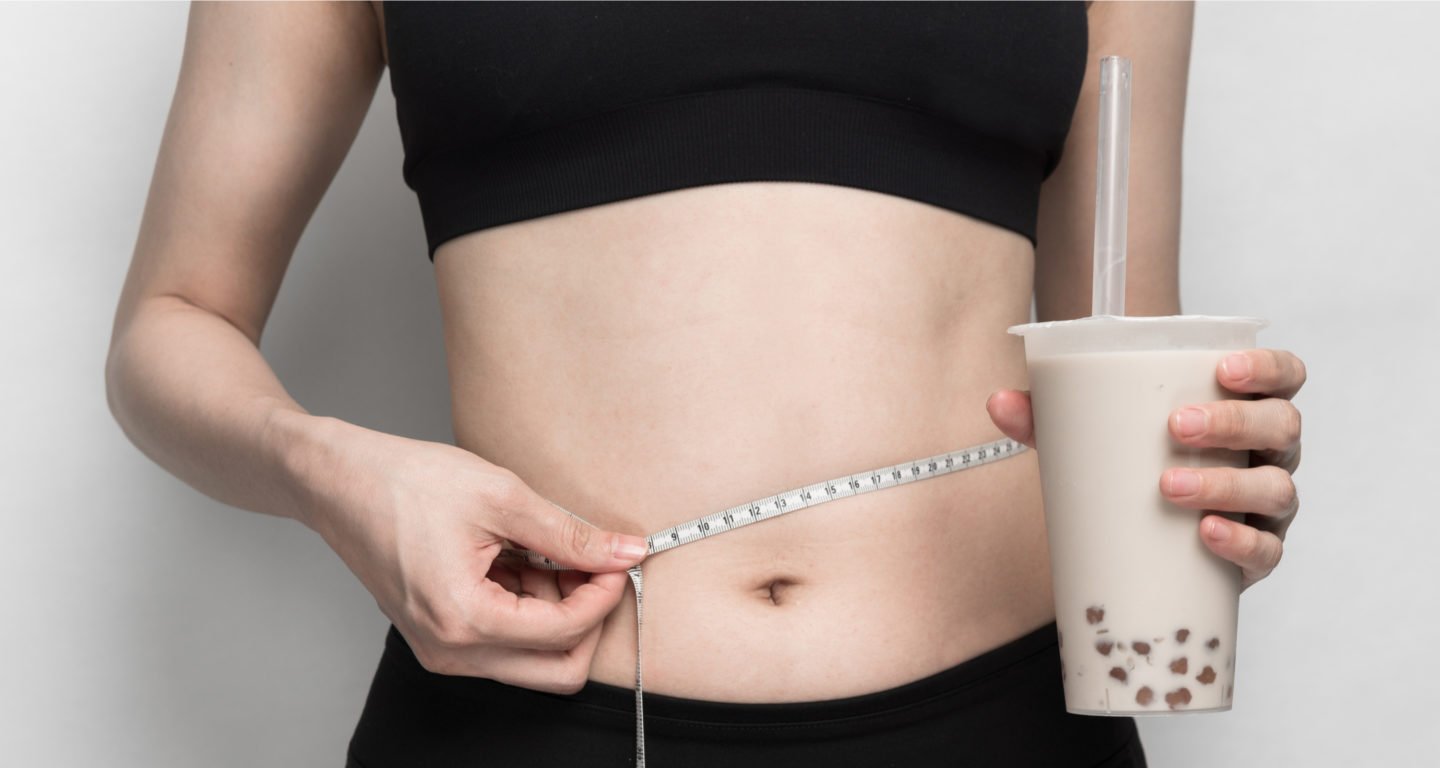 Woman Measuring Waist Holding Boba Tea Drink