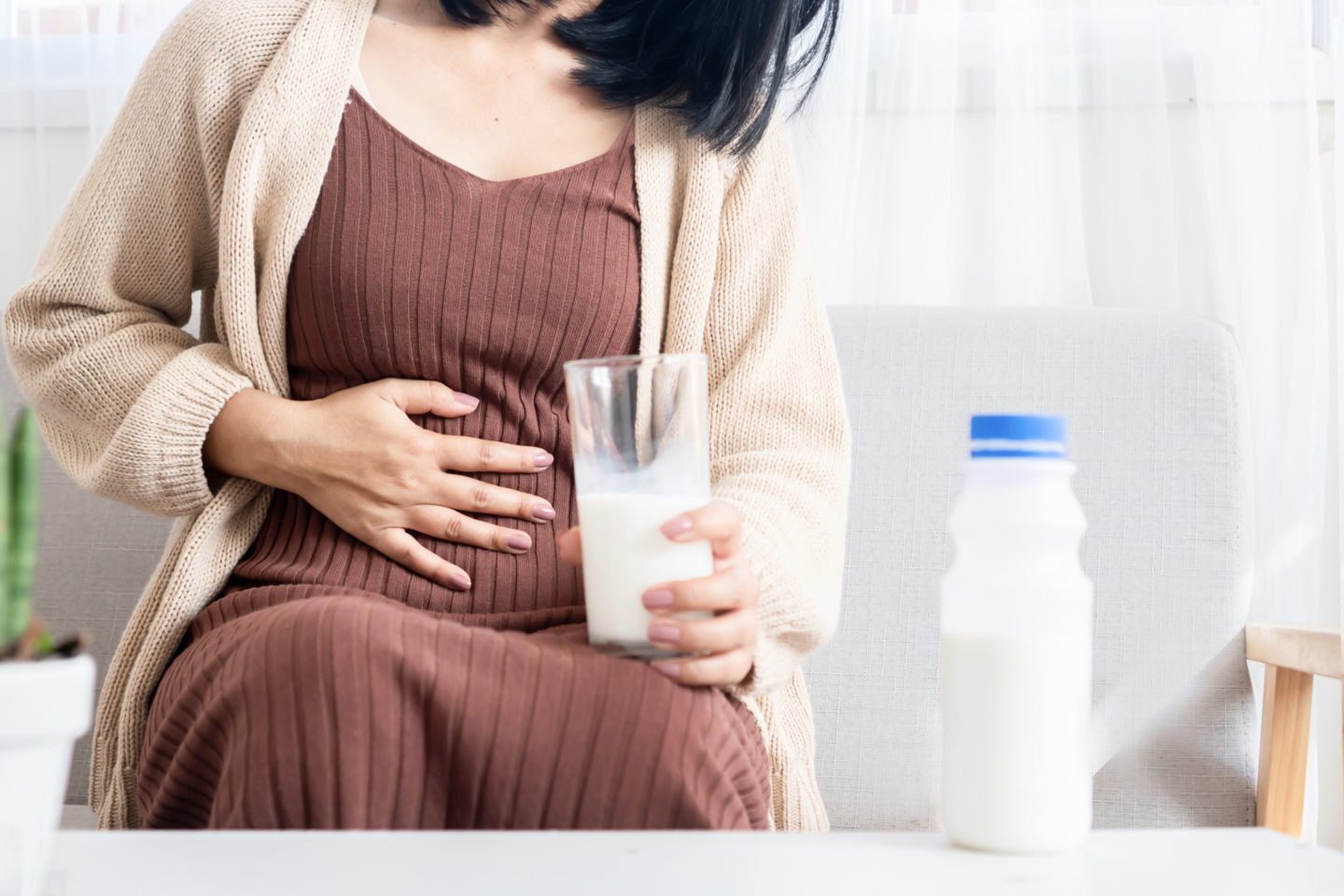 woman with heartburn holding glass of milk