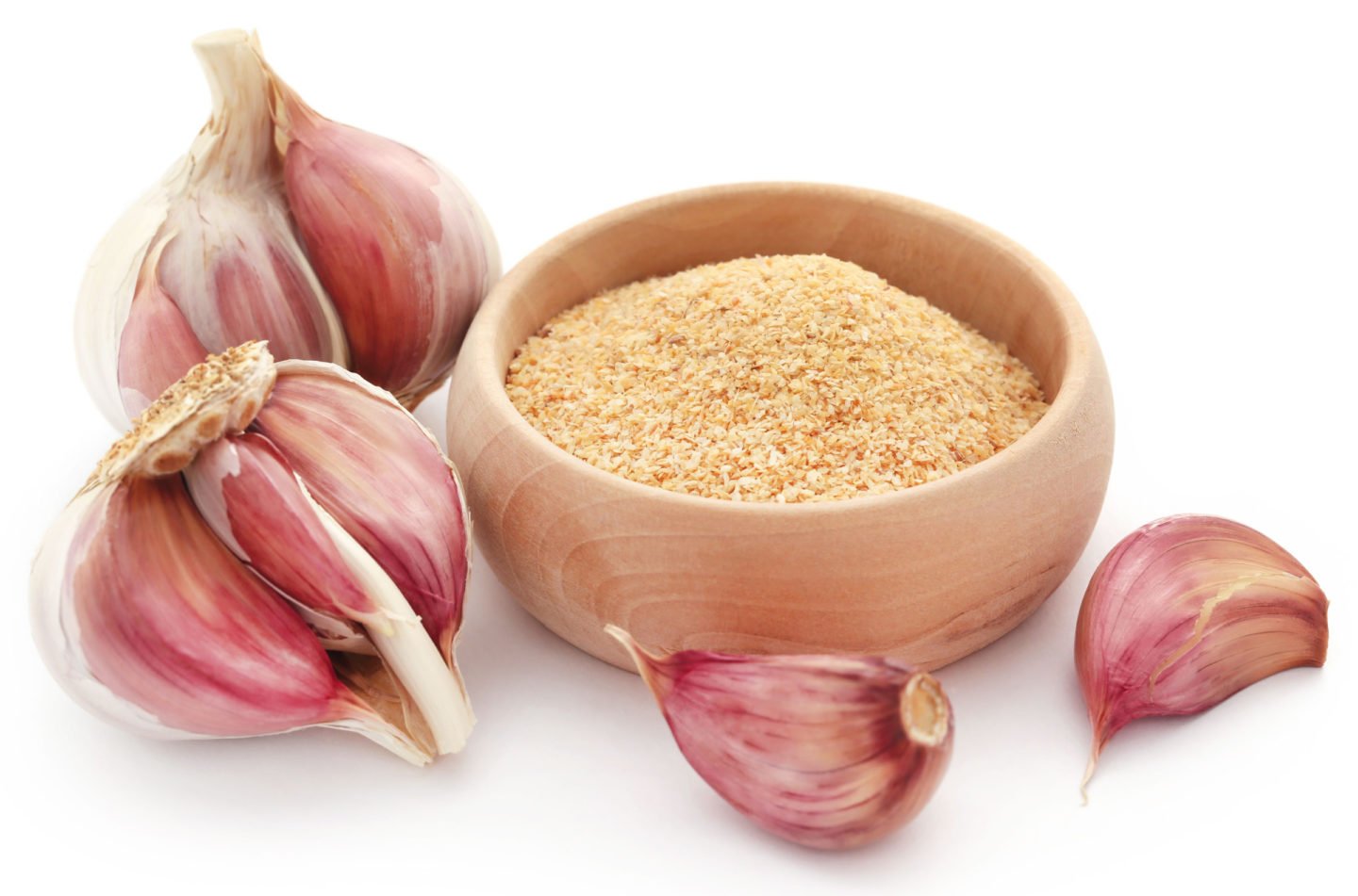 garlic powder in a bowl surrounded by garlic cloves
