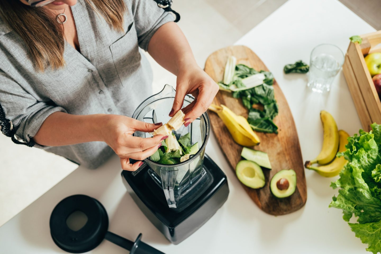 Woman Adding Ingredients To Blender For Smoothie