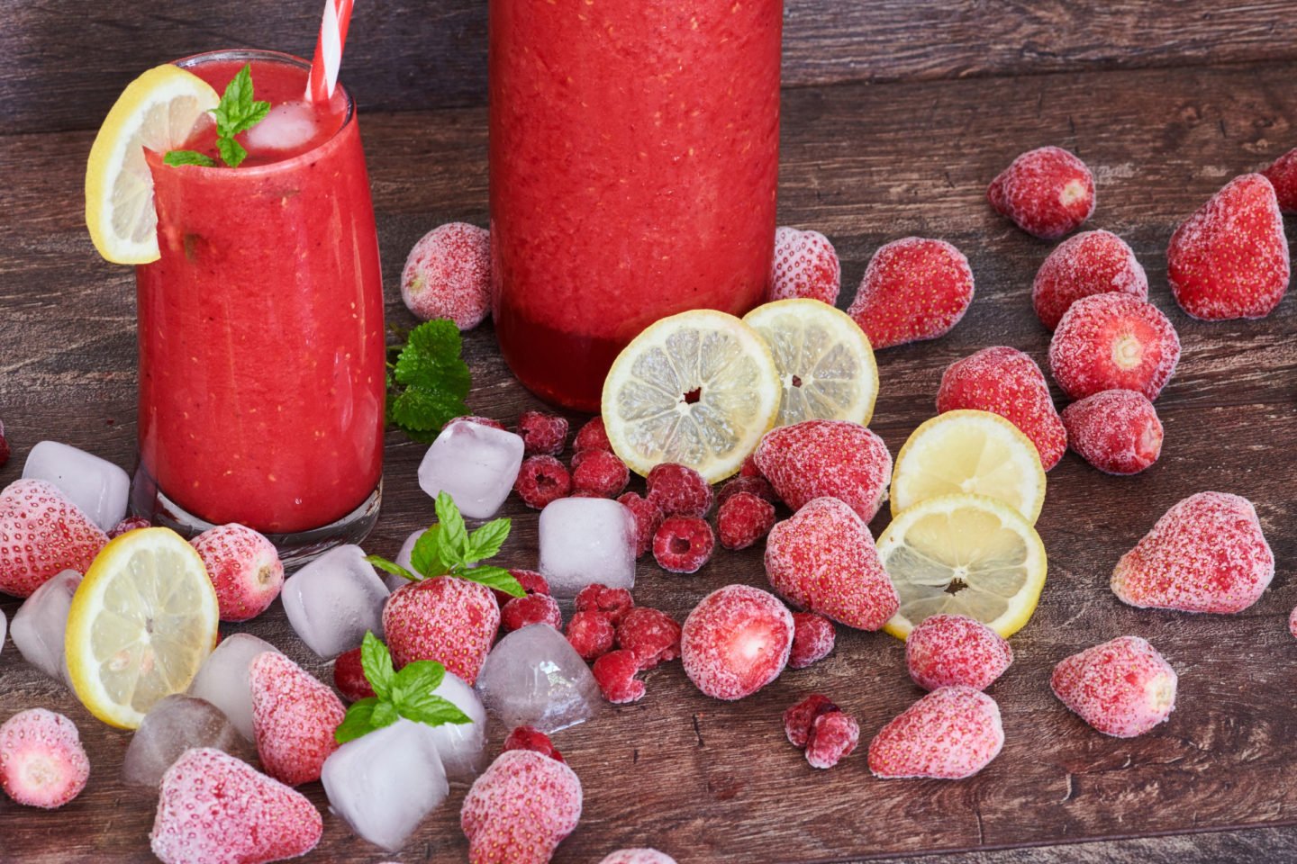 fresh raspberry and strawberry juices with frozen fruits and ice cubes