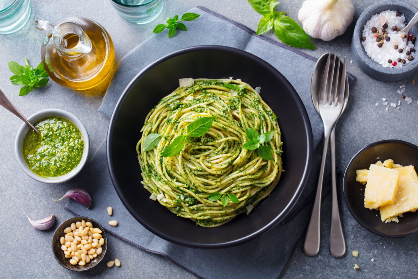 a plate of pesto spaghetti garnished with fresh basil