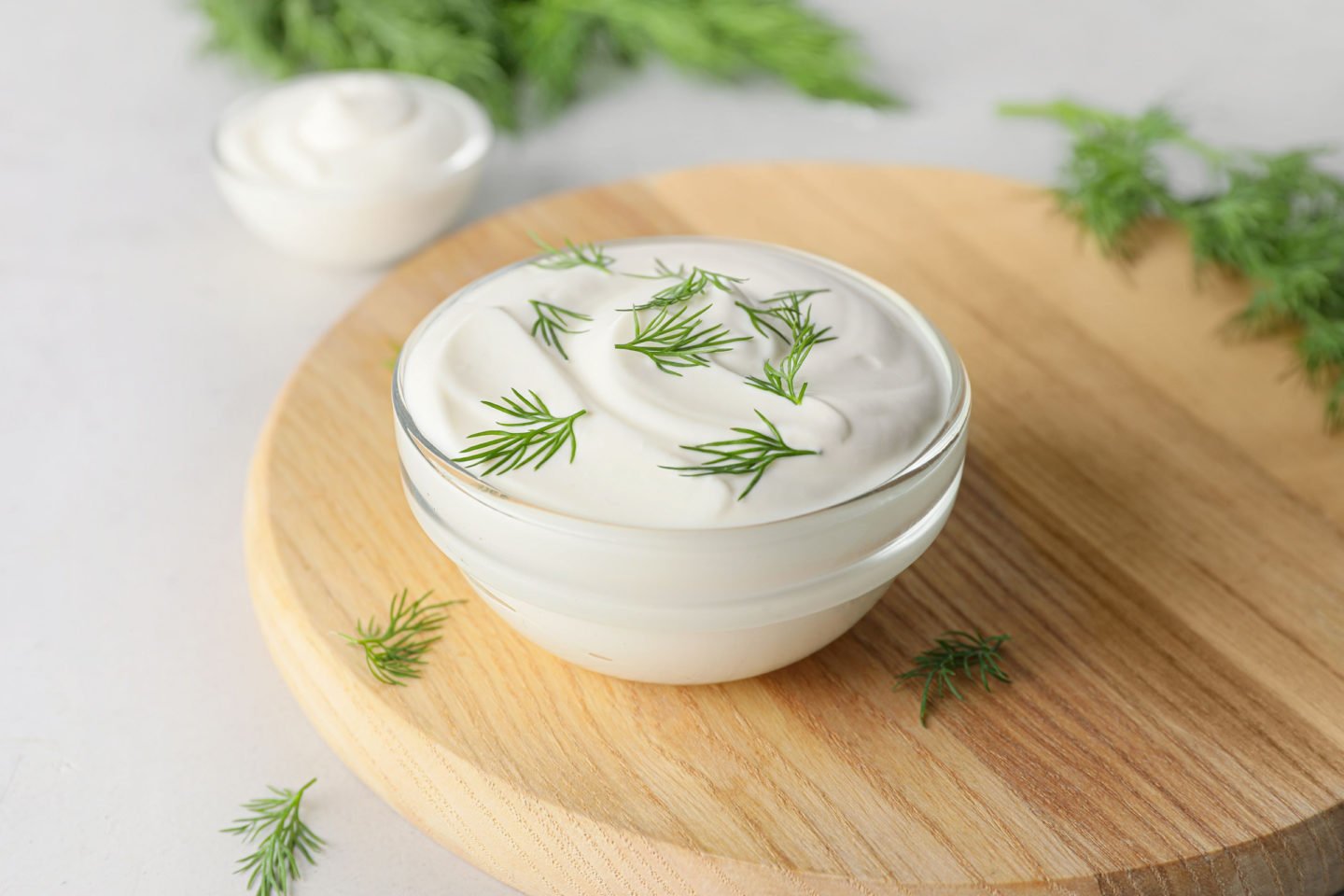 bowl of tasty sour cream on wooden board