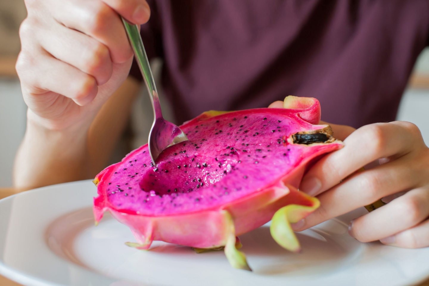 girl eating dragon fruit with spoon