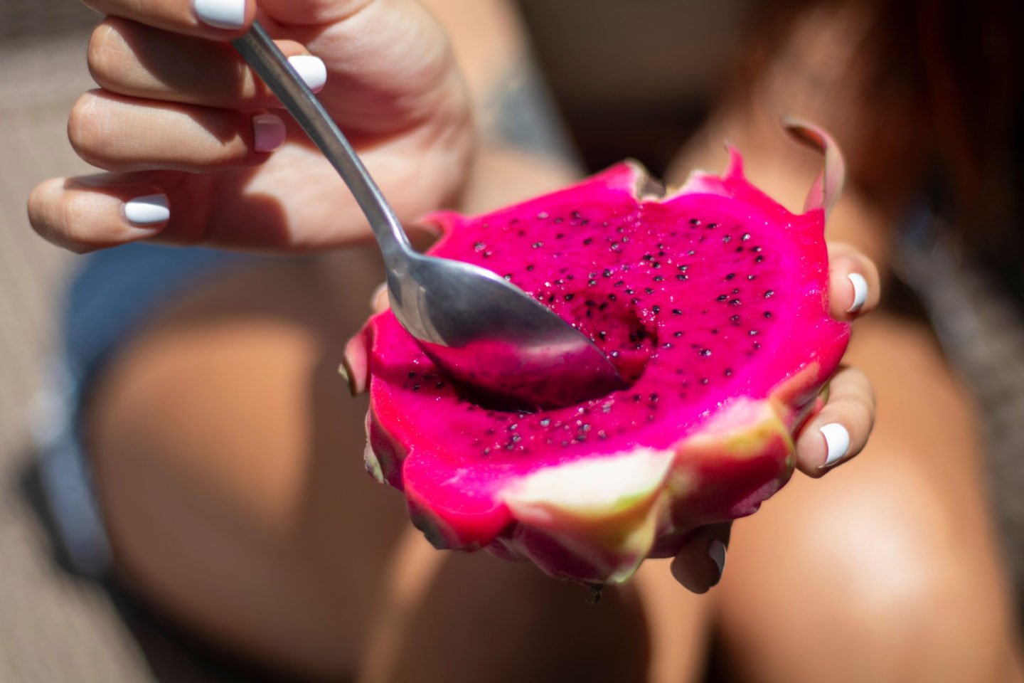 woman eating red dragon fruit