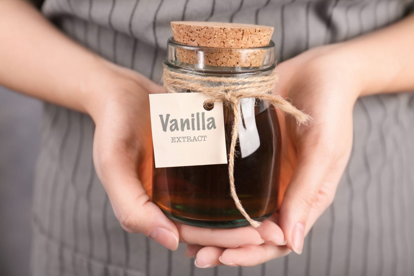 woman holding bottle of vanilla extract