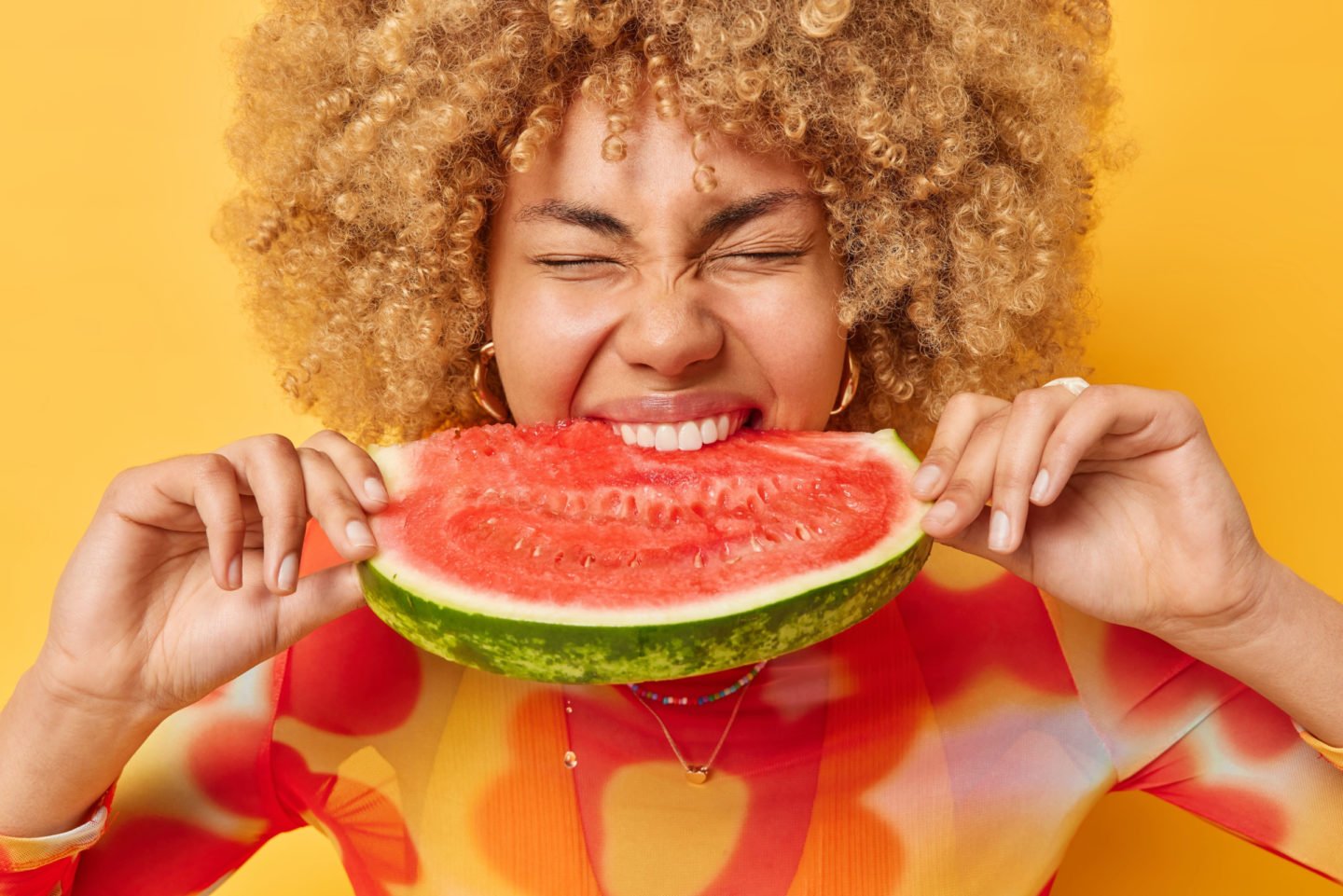 young woman eating a slice of watermelon