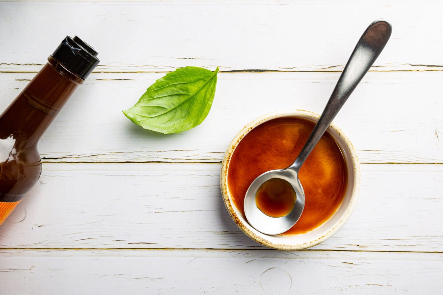 Worcestershire sauce in a bowl with spoon and bottle