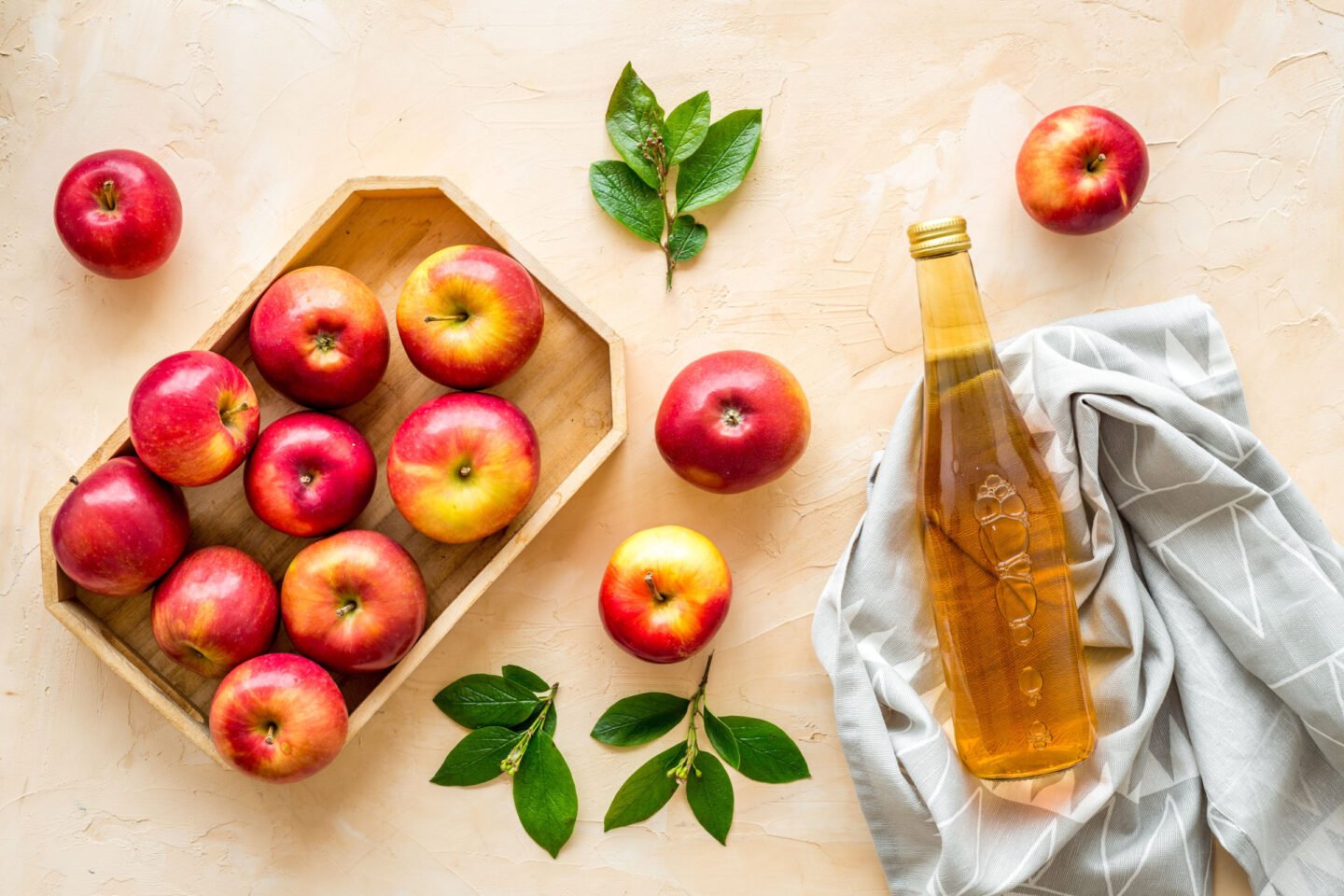 bottle of apple cider vinegar with red apples