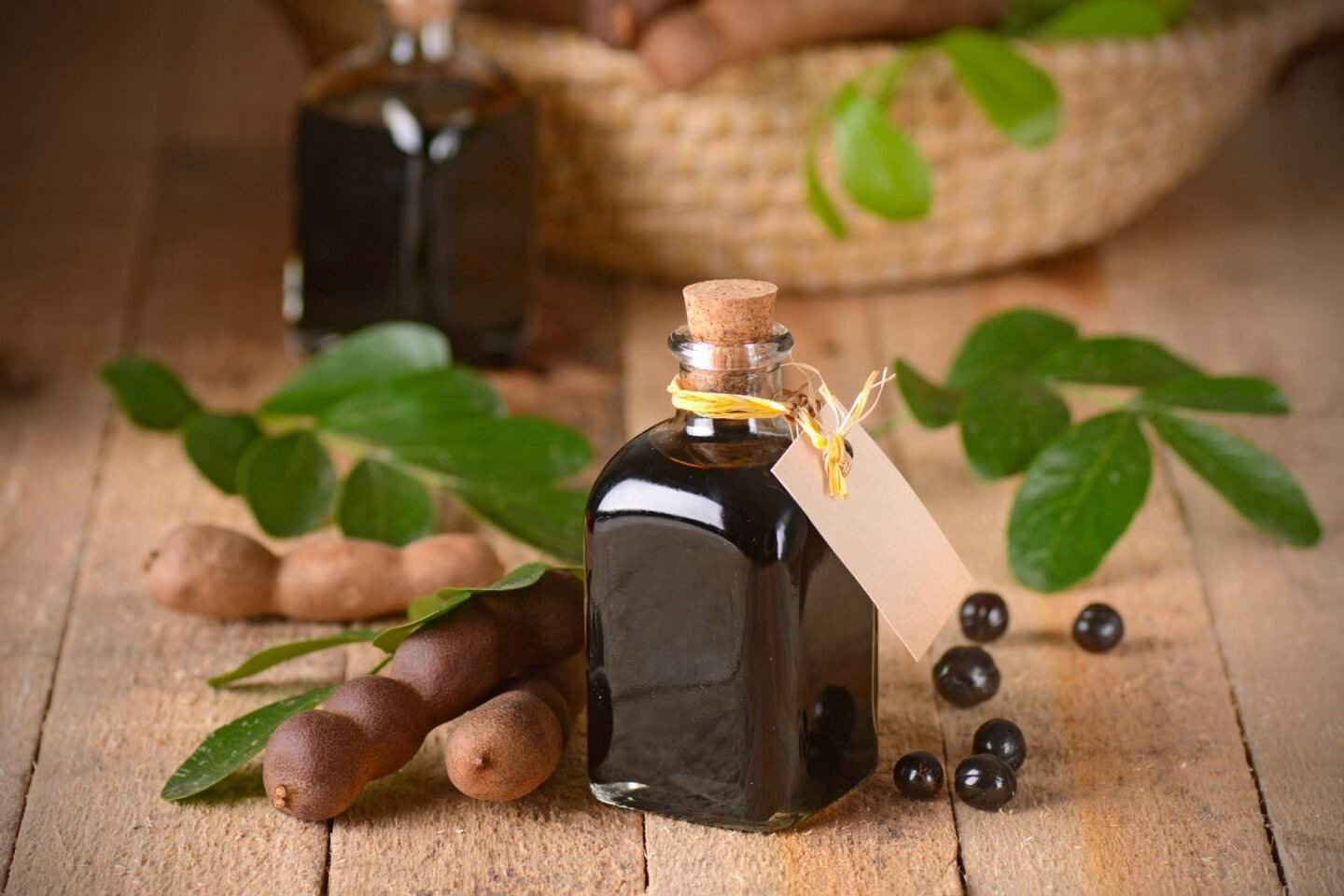 bottle of tamarind concentrate with fresh tamarind pods