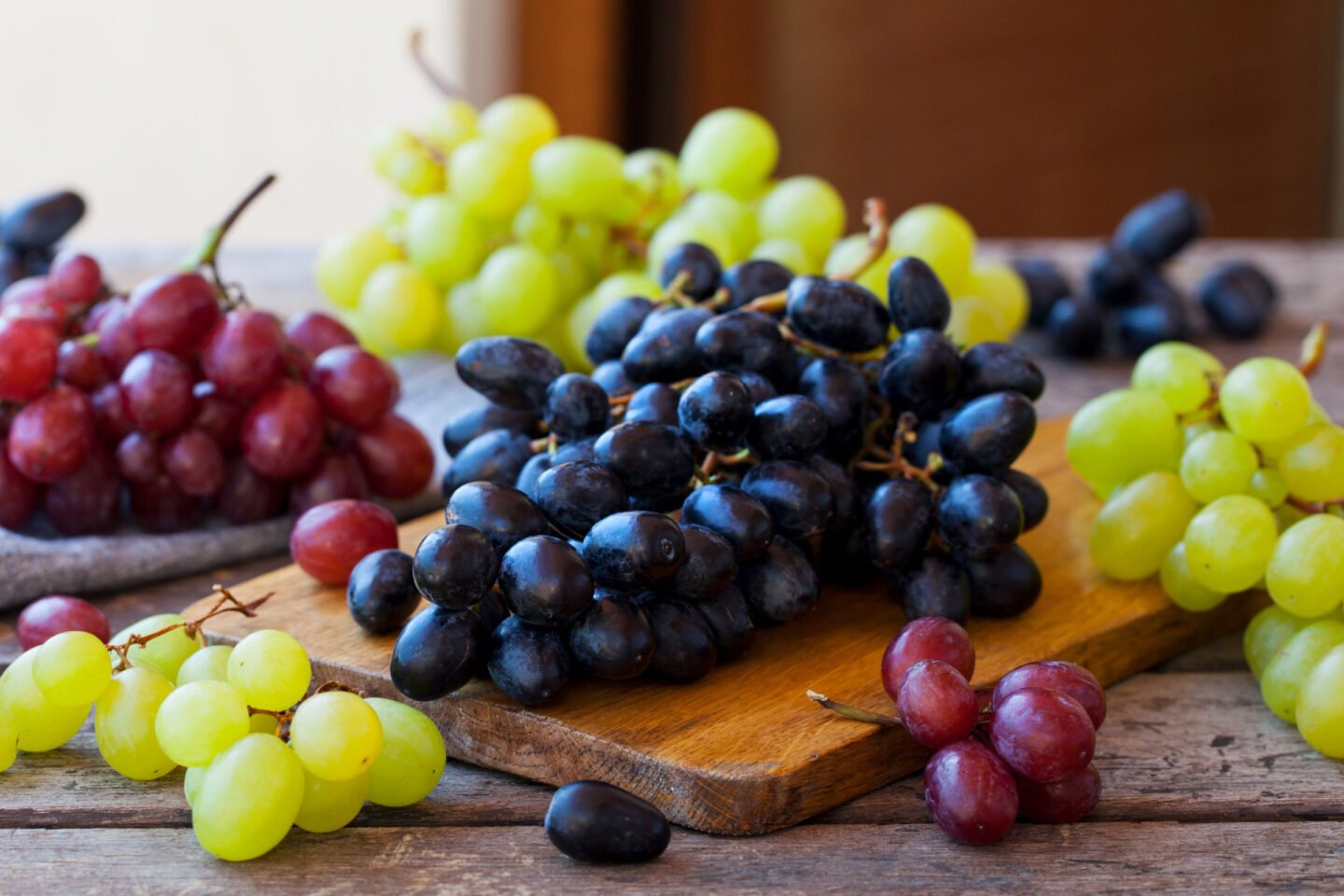different kinds of grapes on wooden table