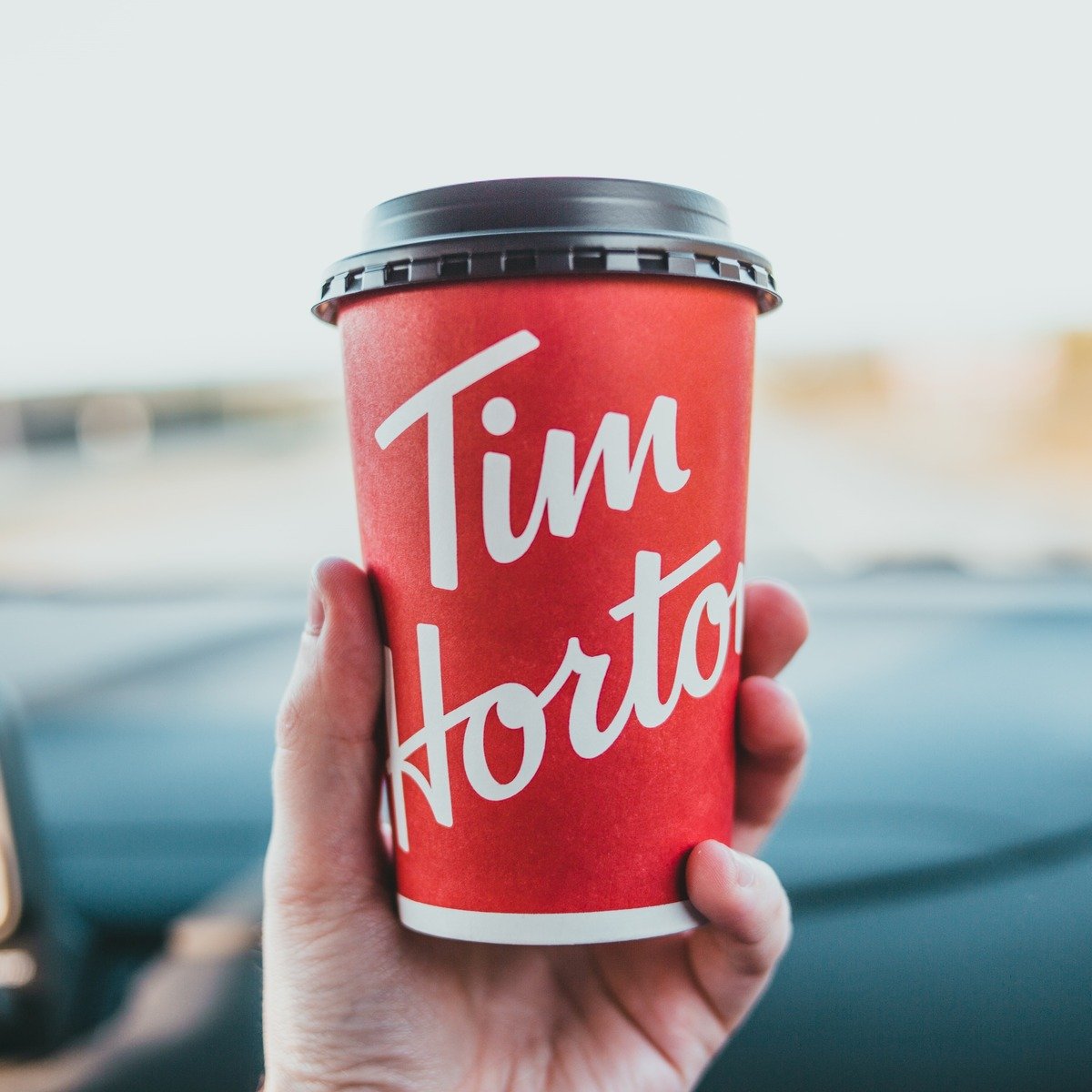 hand holding up tim hortons cup