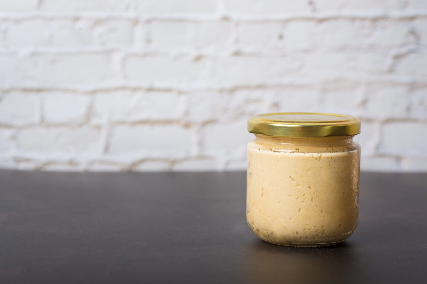 Hummus,In,A,Jar,On,A,Black,Background.,Hummus,Spread