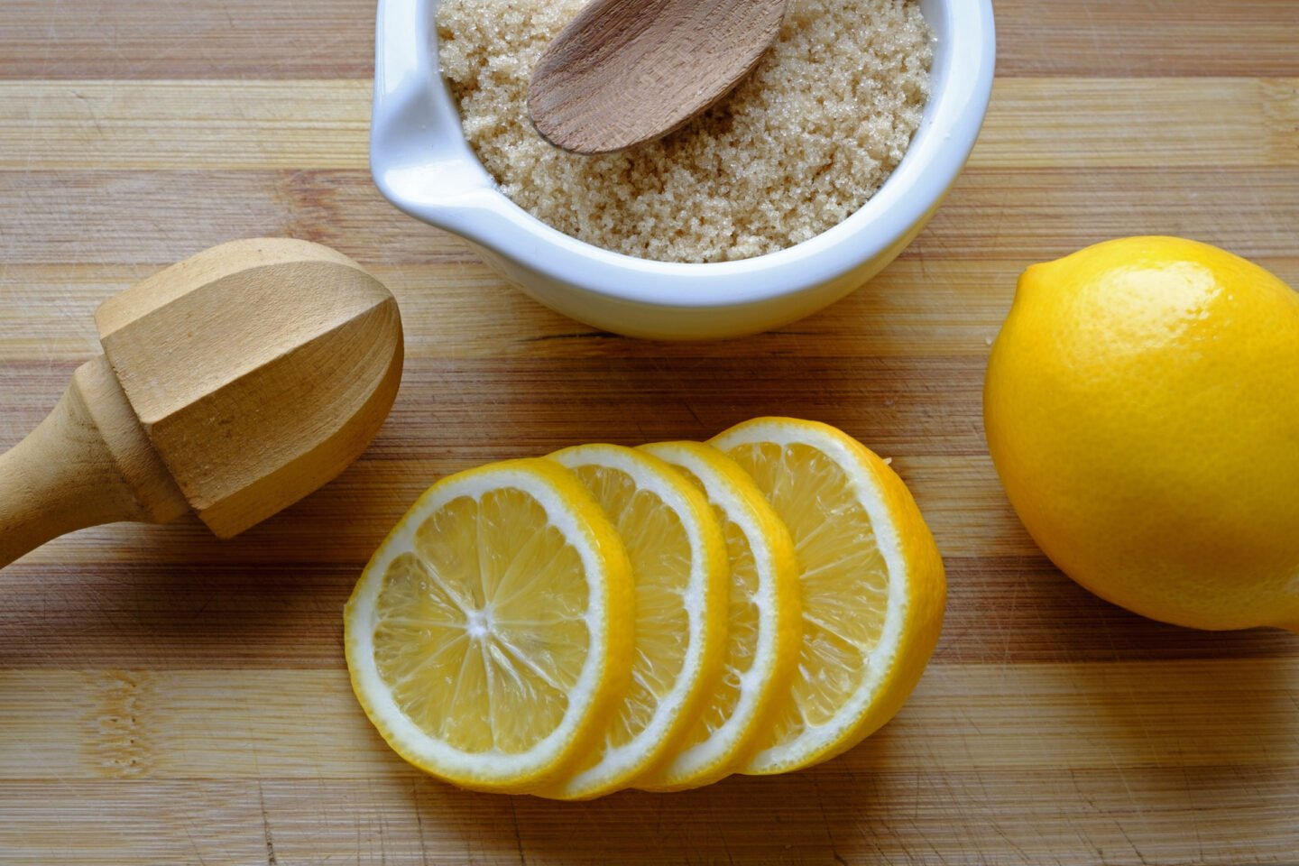 lemons and brown sugar in bowl with wooden reamer