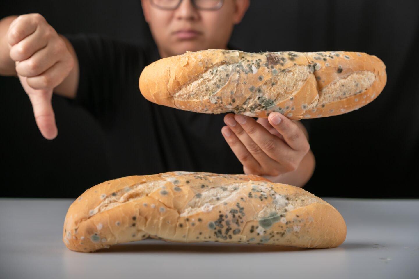 Man,Eating,Moldy,Dirty,Bread.,Man,Standing,Holding,Moldy,Bread.