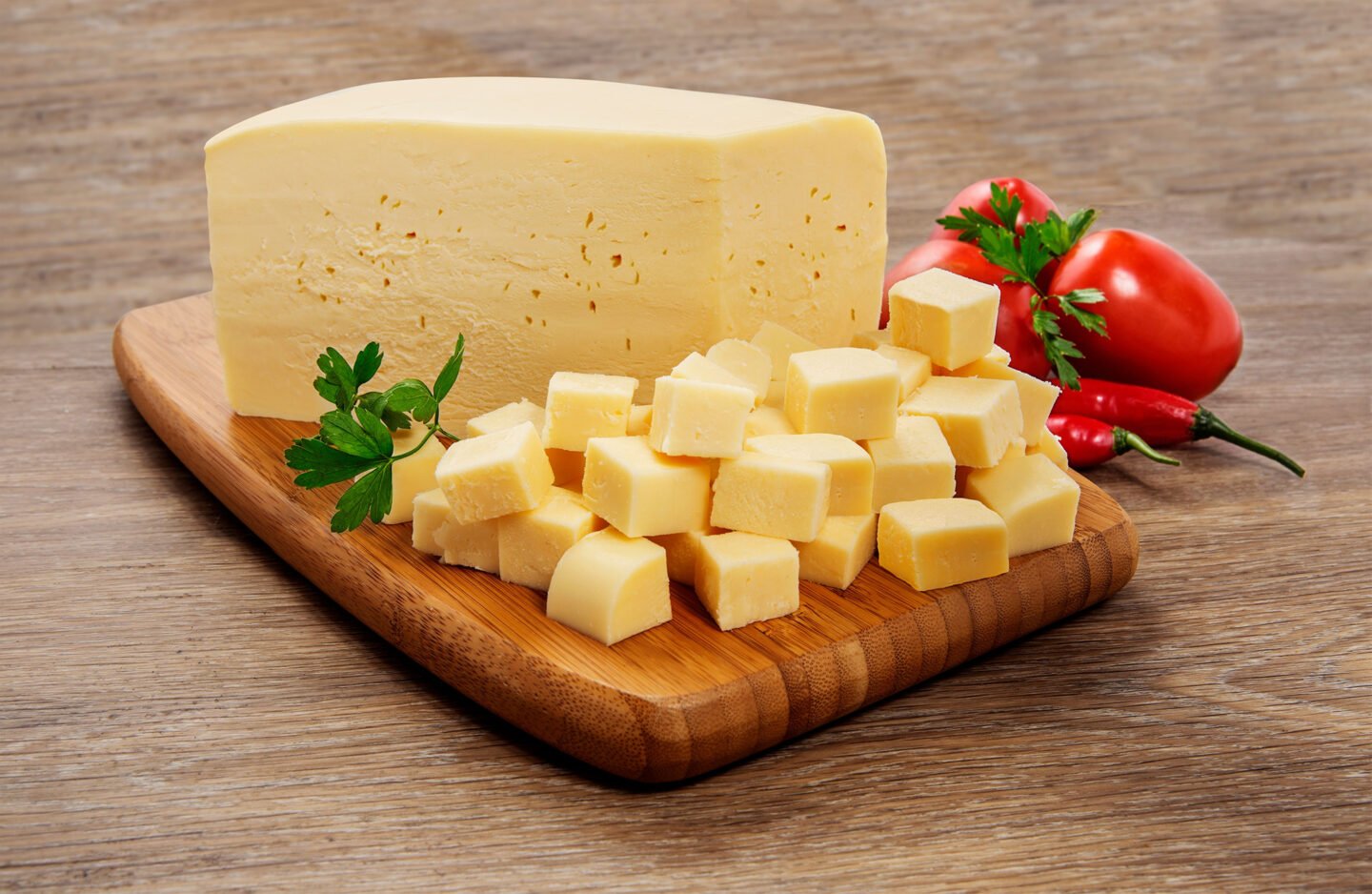 mozzarella cheese block and cubes on cutting board