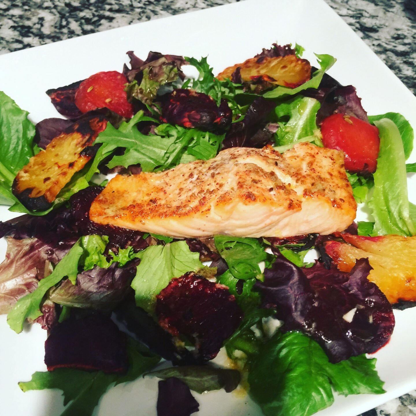 organic oven broiled salmon on a bed of greens
