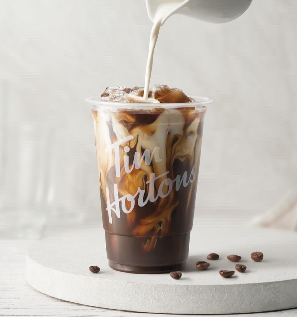 pouring cream into cup of tim hortons cold brew