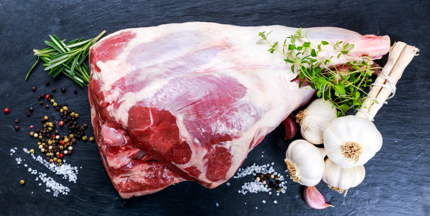 Raw,Lamb,Leg,On,Blue,Stone,Background