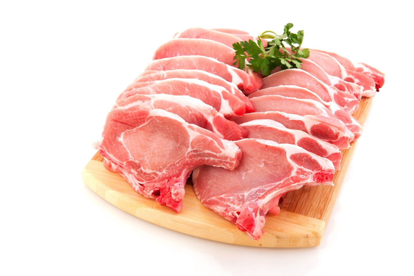 raw pork chops on wooden board