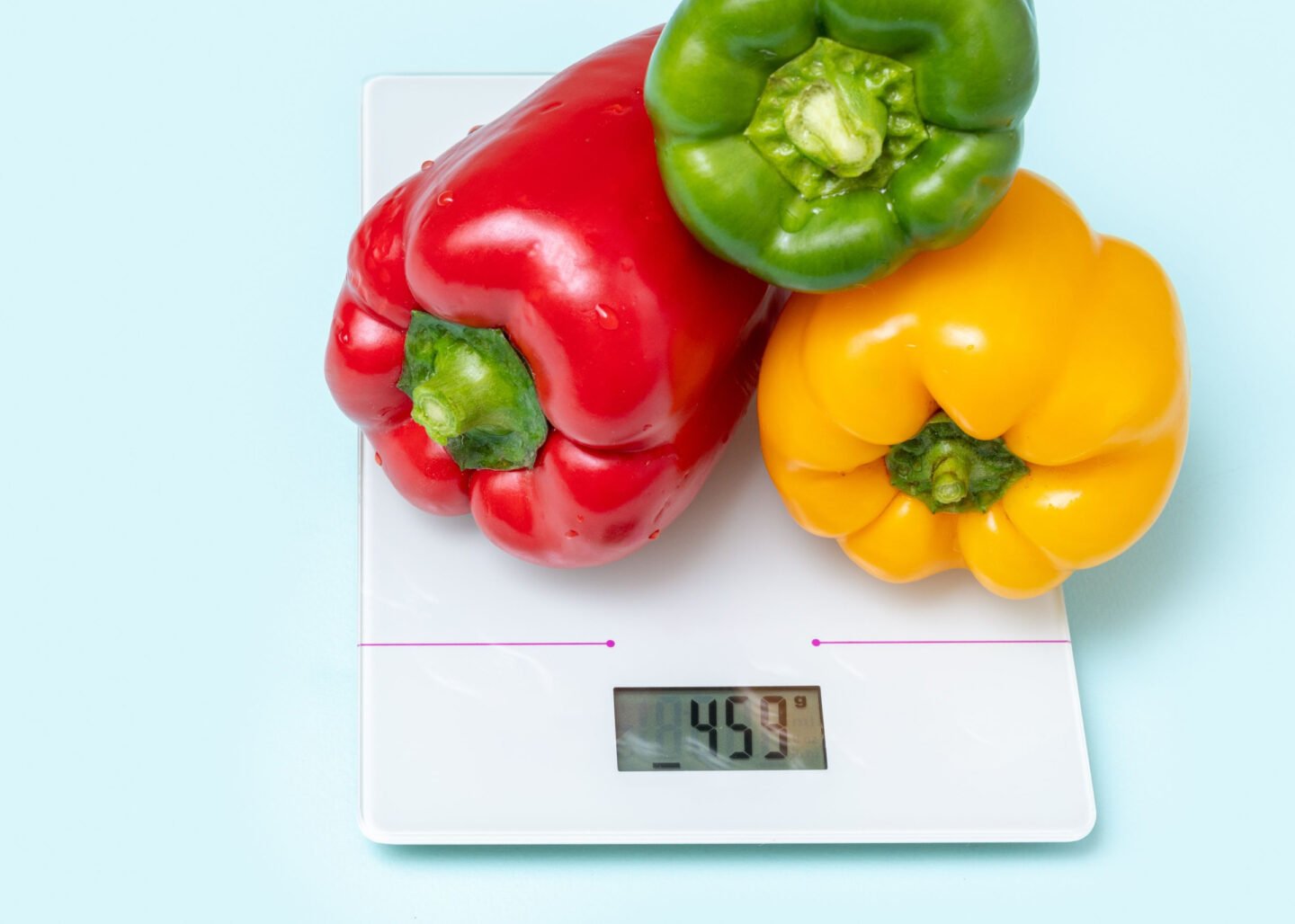 red yellow green bell peppers on a kitchen scale