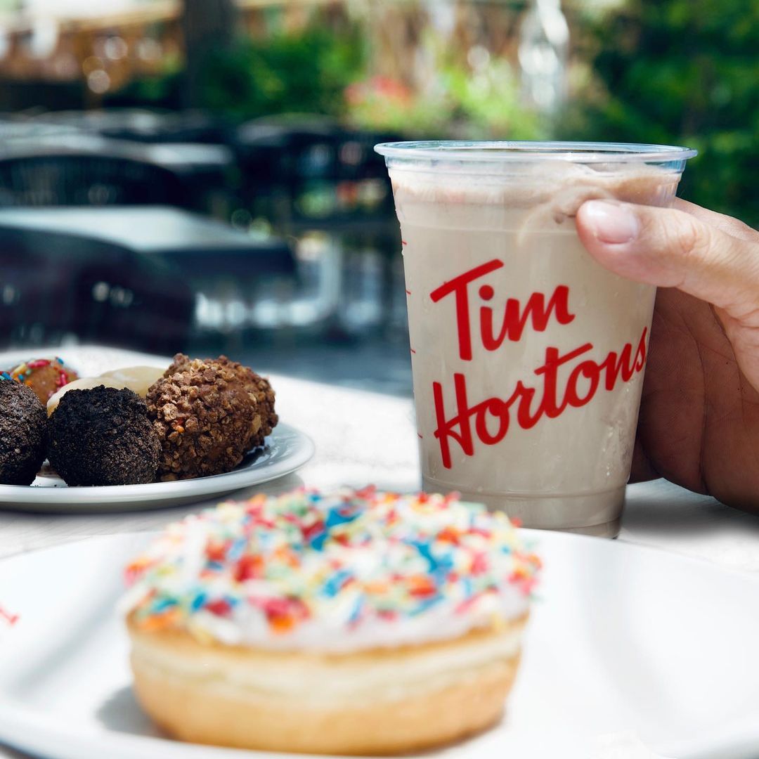 tim hortons iced french vanilla latte on table with donuts