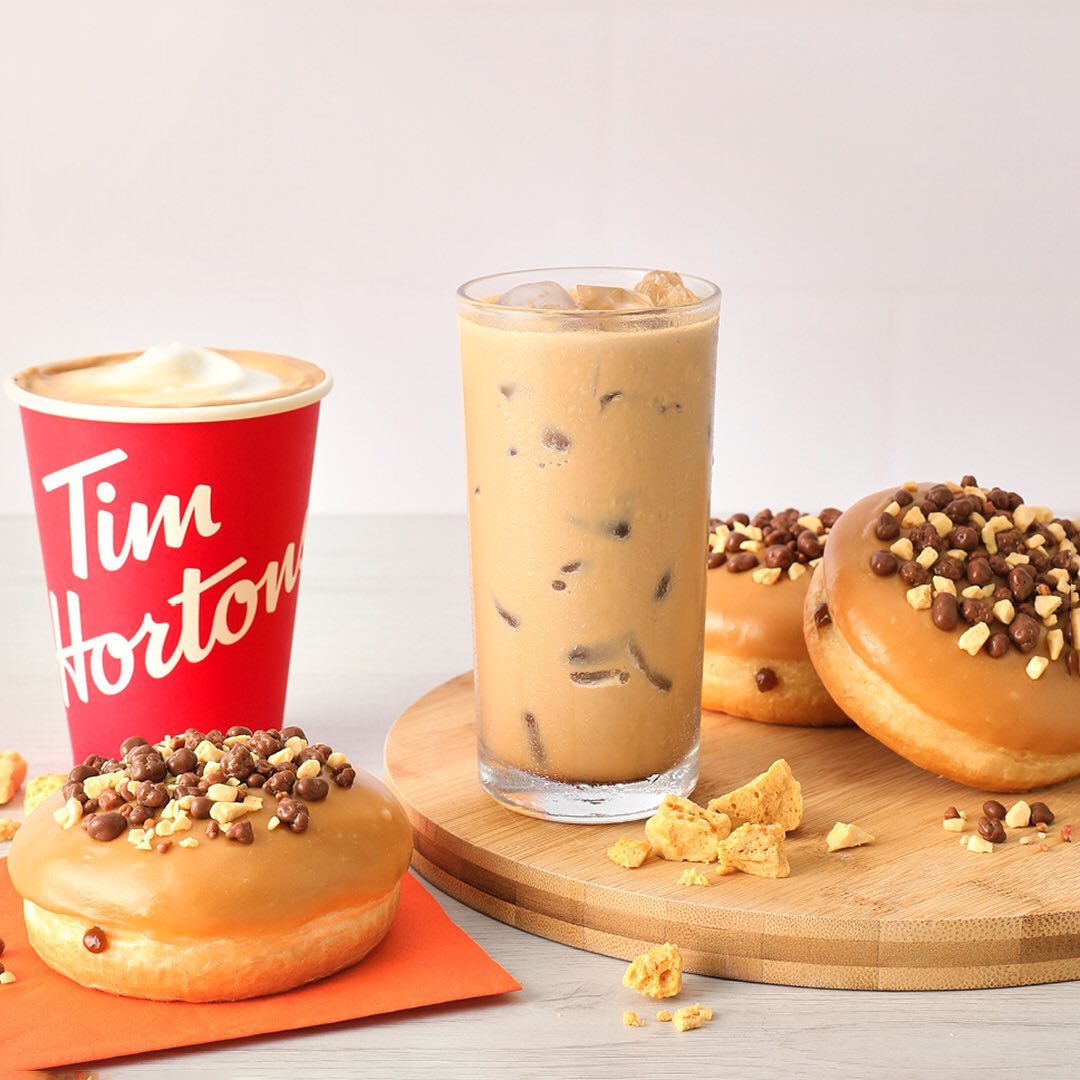 tim hortons latte and iced latte beside donut on table