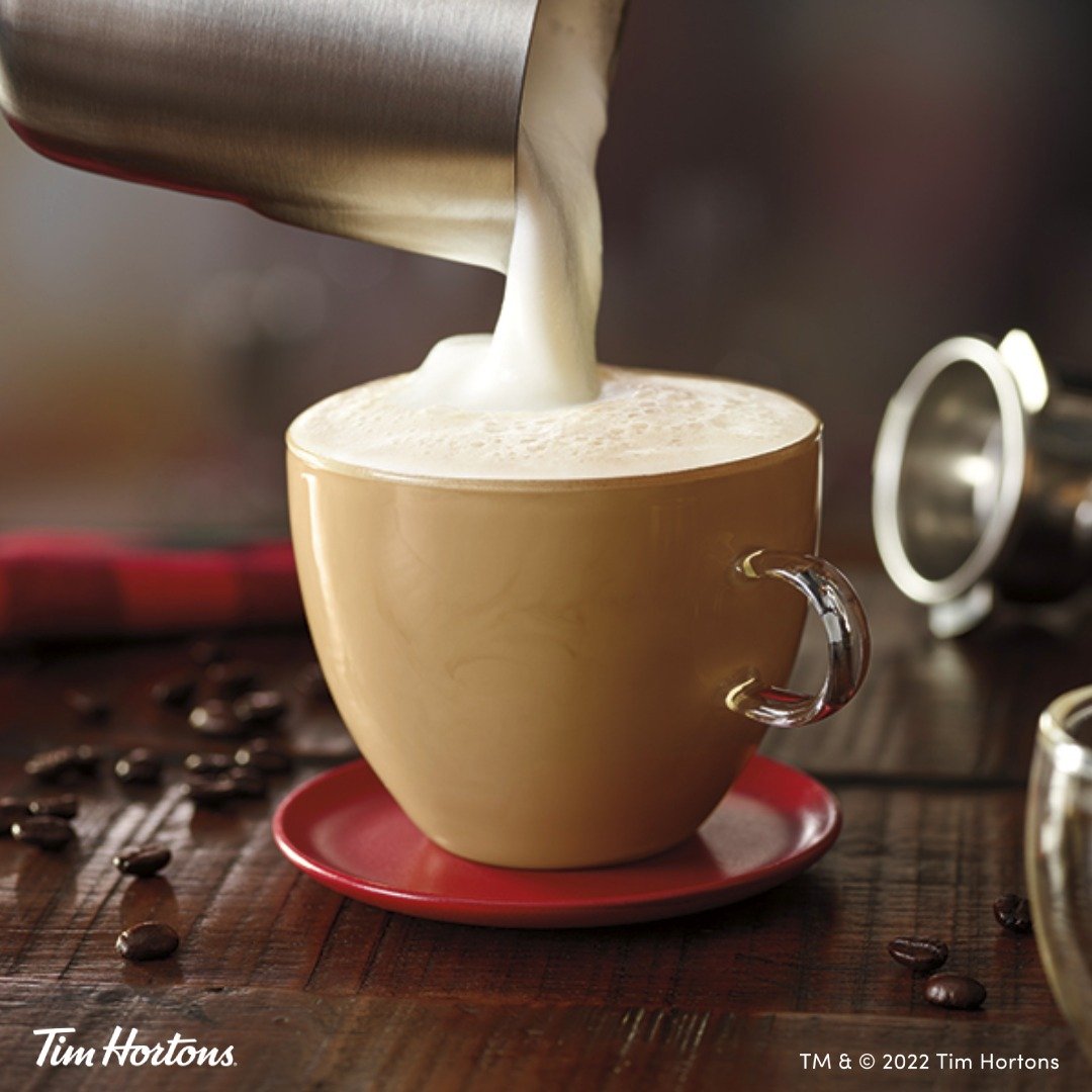 tim hortons pouring foam on top of steaming cappucino