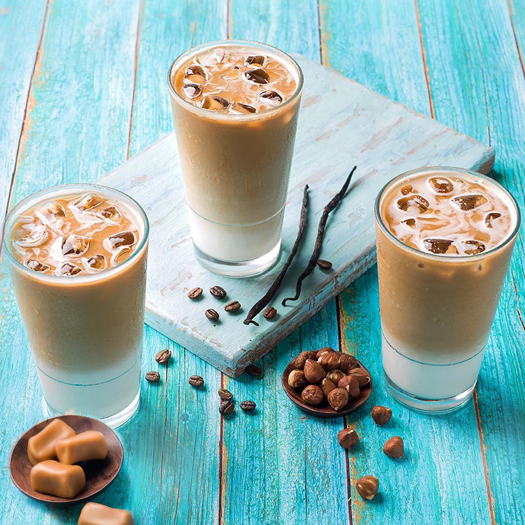 tim hortons three iced lattes on blue wood table