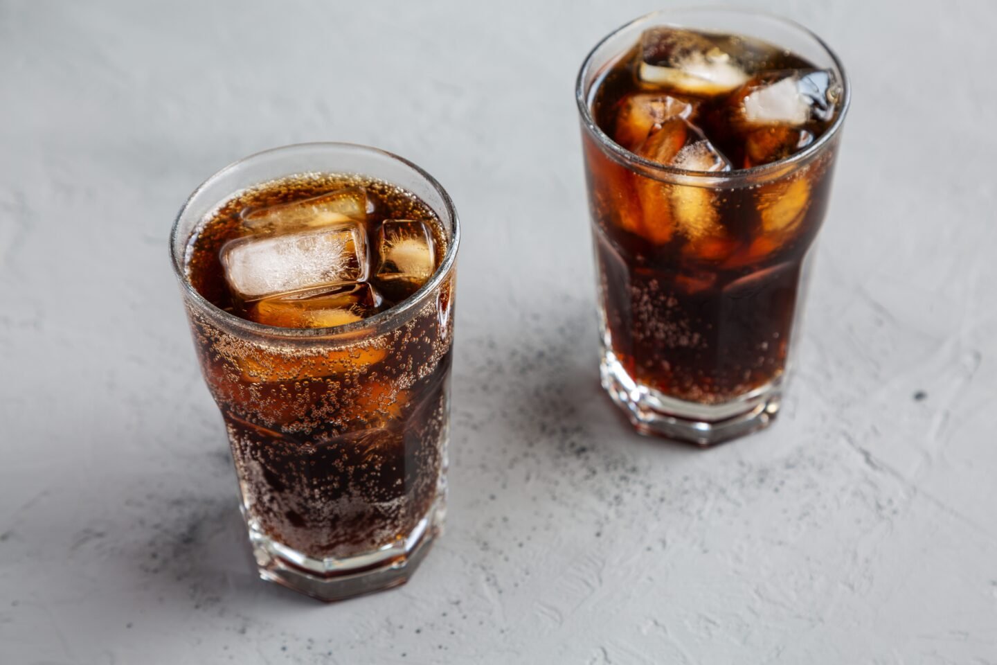 Cold,Refreshing,Dark,Cola,With,Ice,Cubes,On,A,Gray