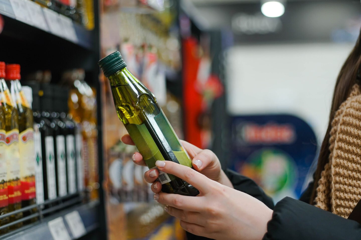 woman buying olive oil at supermarket
