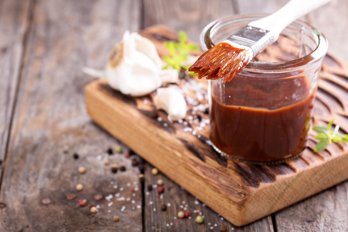 bbq sauce in a jar with basting brush