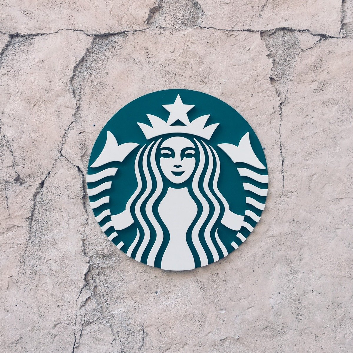 close up of starbucks logo on cracked wall