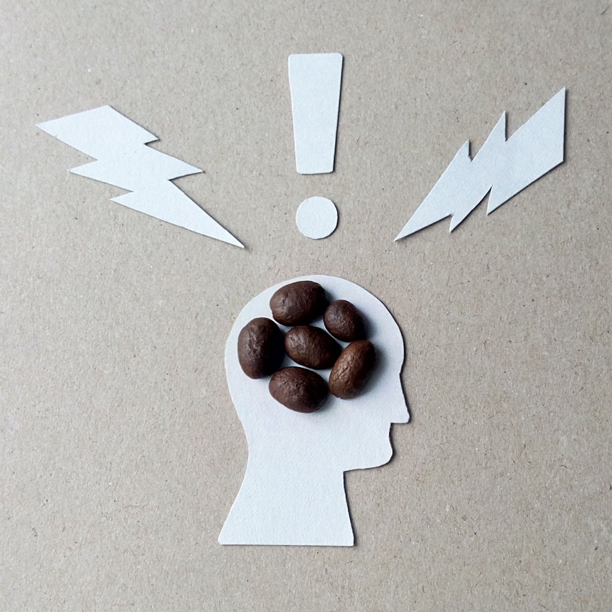 coffee beans in cardboard cutout person's head exclamation point on top