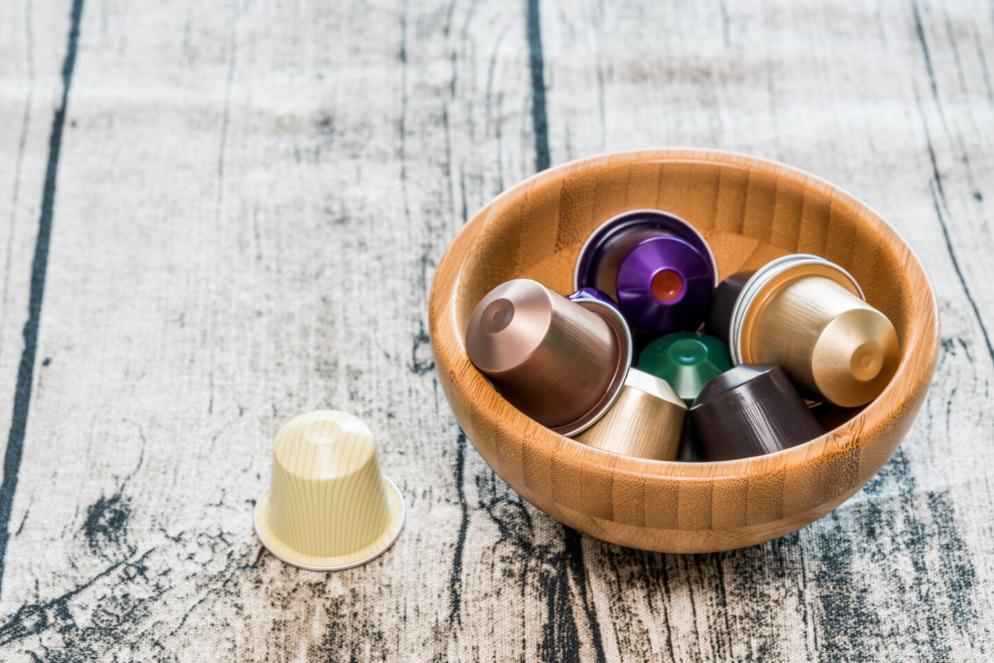 Modern,Coffee,Pods,In,A,Bamboo,Bowl,On,Wooden,Background.