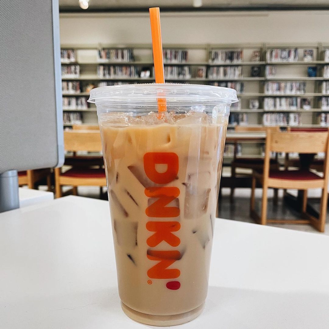 cup of dunkin donuts iced coffee on white table in classroom or library