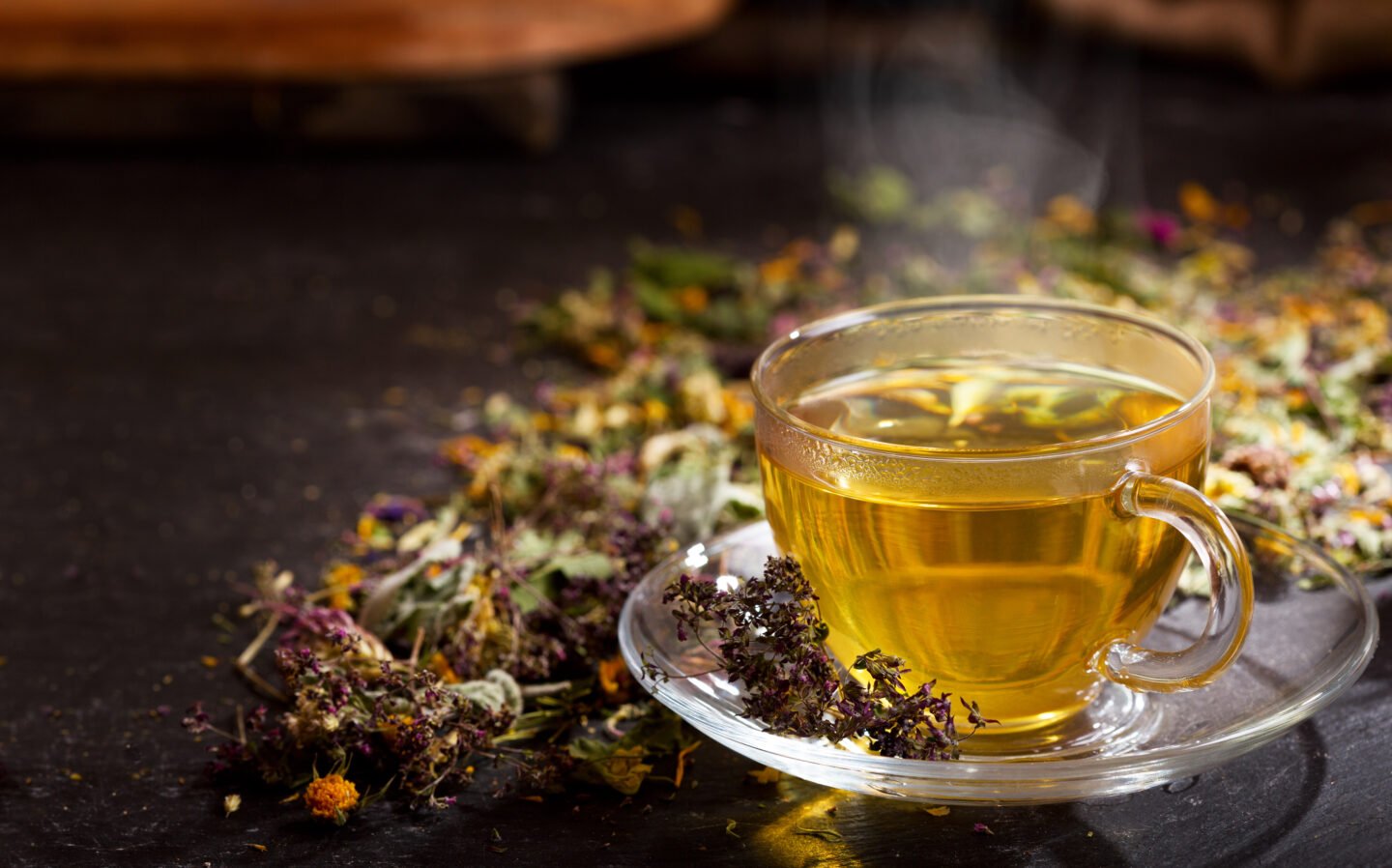 Cup,Of,Herbal,Tea,With,Various,Herbs,On,Dark,Background