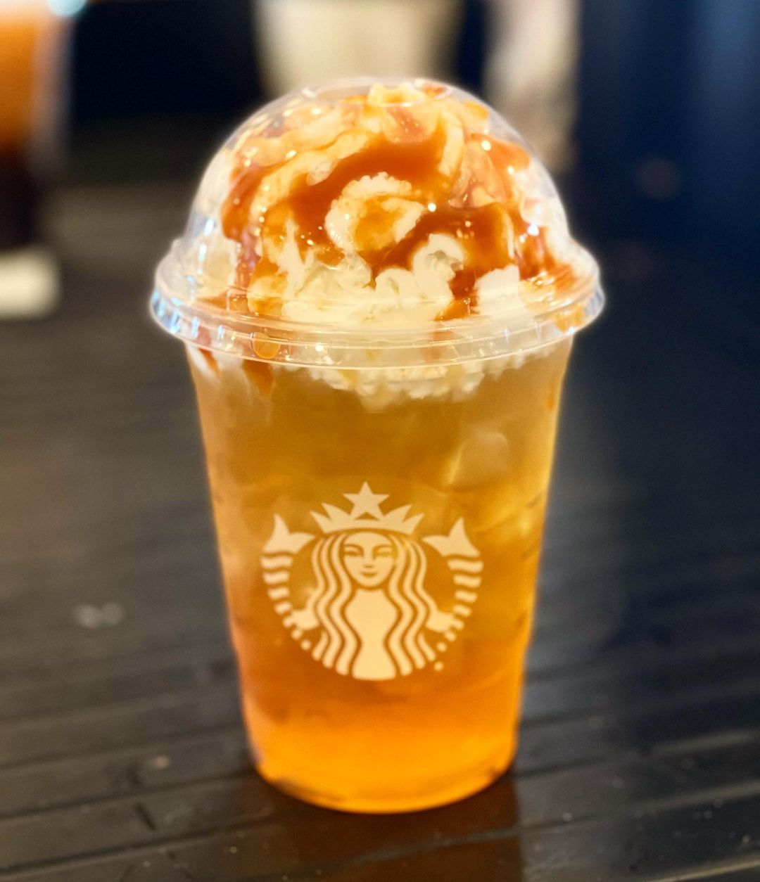 cup of starbucks iced caramel apple spice on table