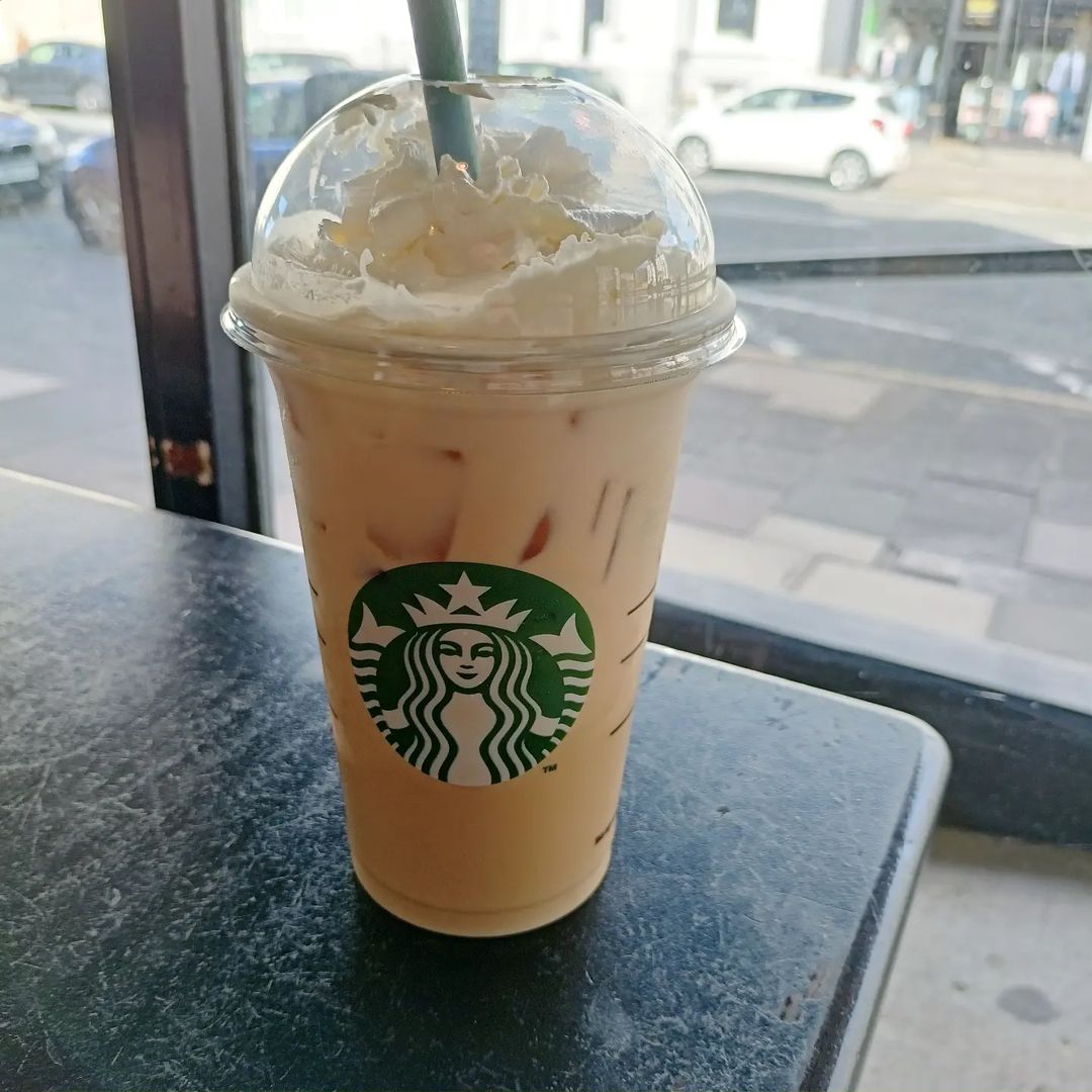 cup of starbucks iced white chocolate mocha on wooden table