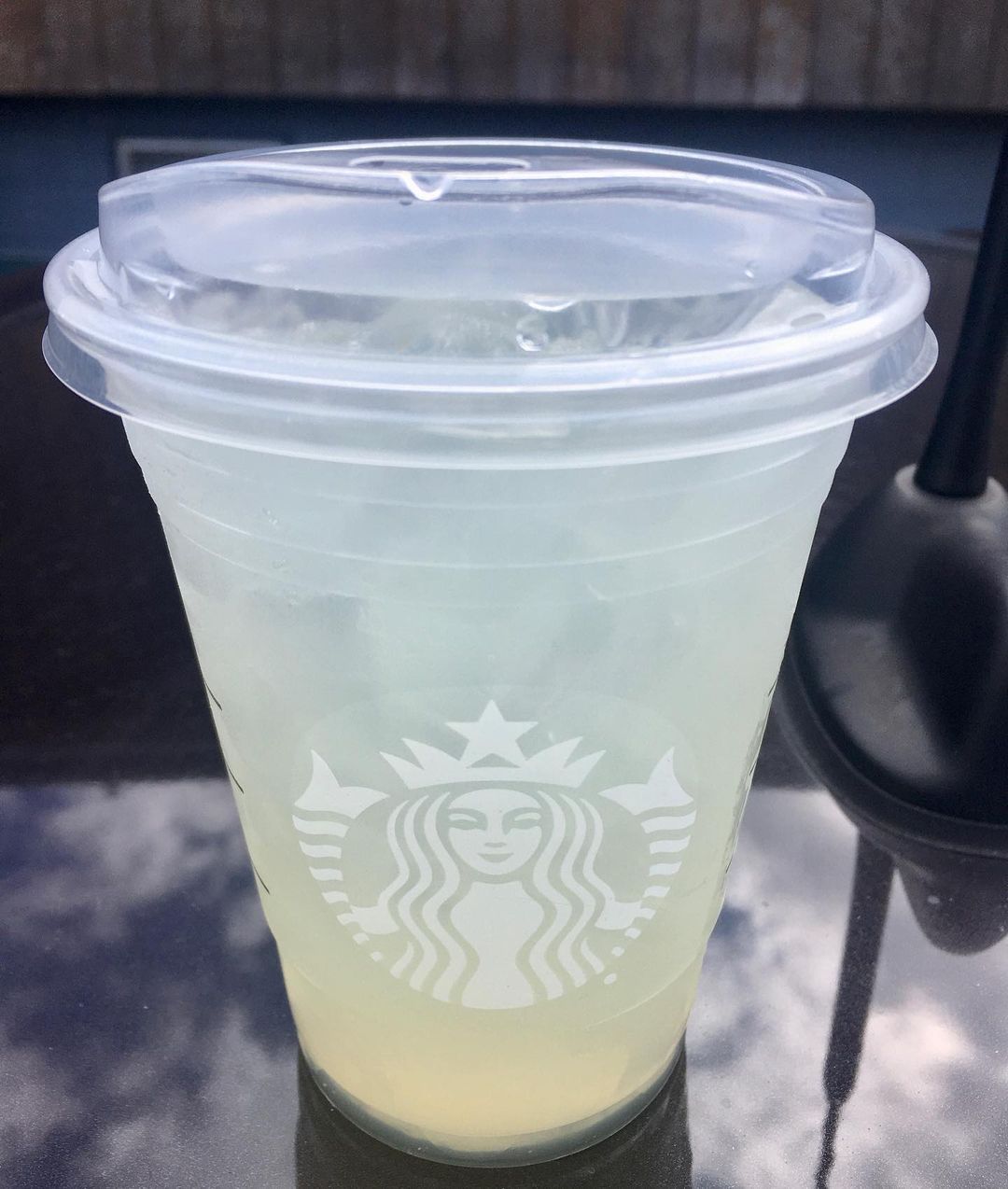 cup of starbucks lemonade on glass surface