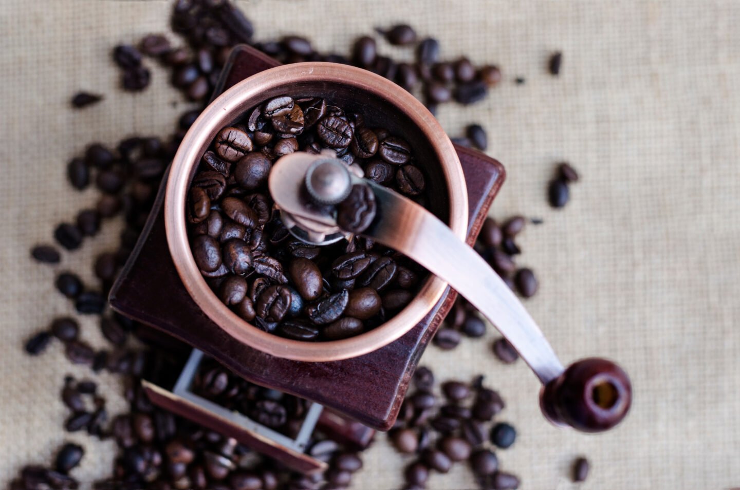 Coffee,Beans,And,A,Wooden,Grinder