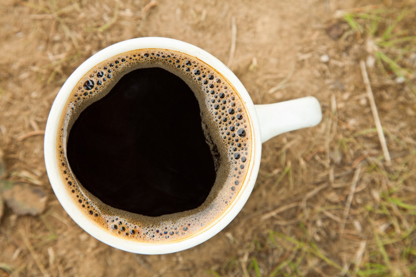 Close up,Cup,Of,Fresh,Coffee,On,The,Ground