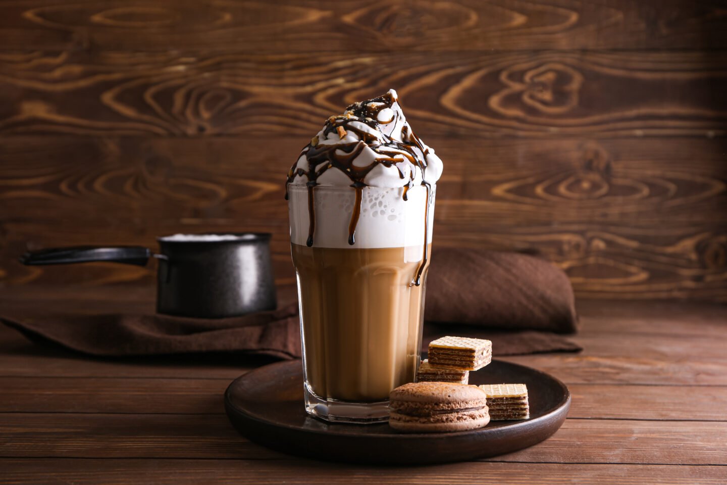 Glass,Of,Tasty,Frappe,Coffee,With,Sweets,On,Wooden,Table