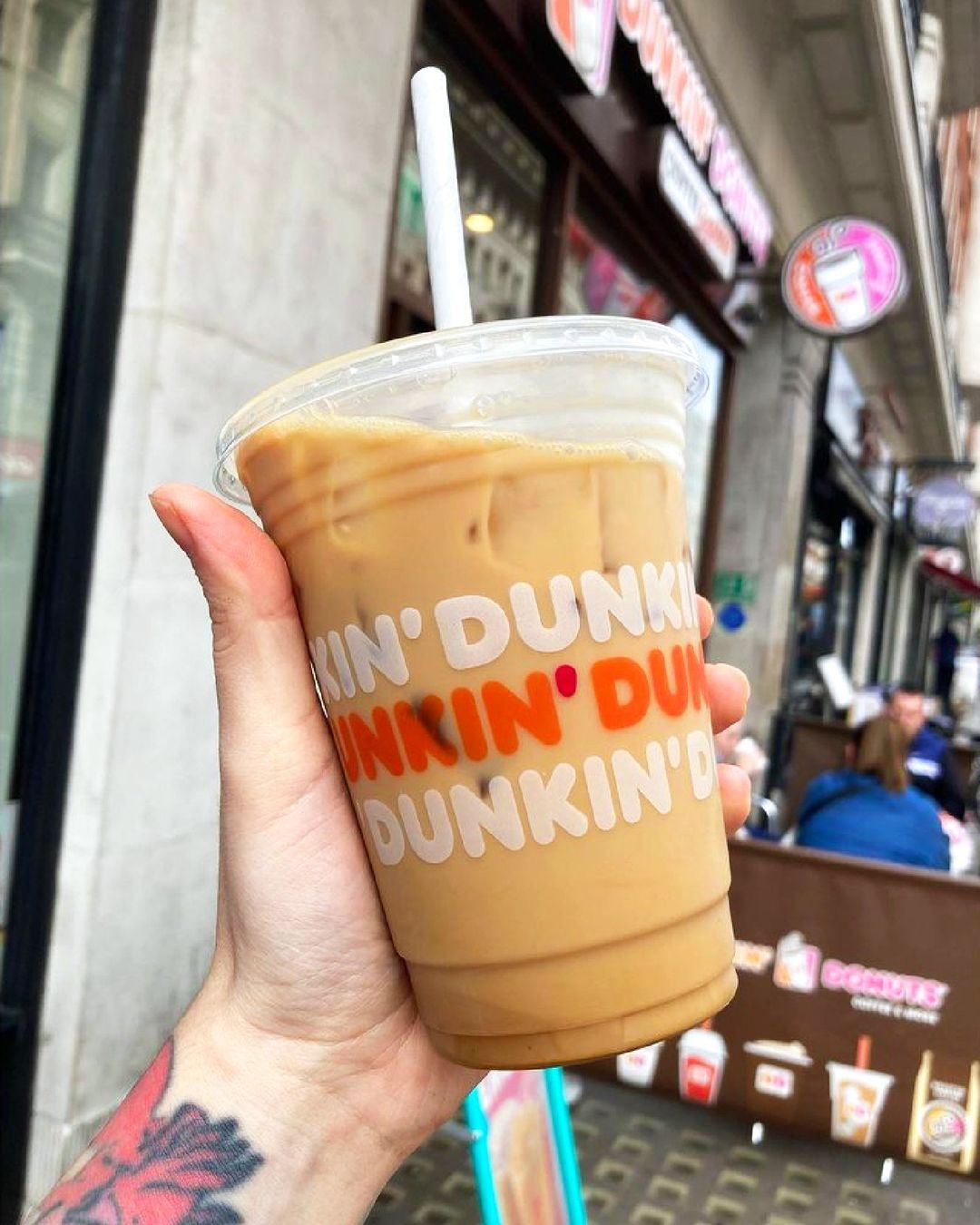 hand holding cup of dunkin donuts iced latte