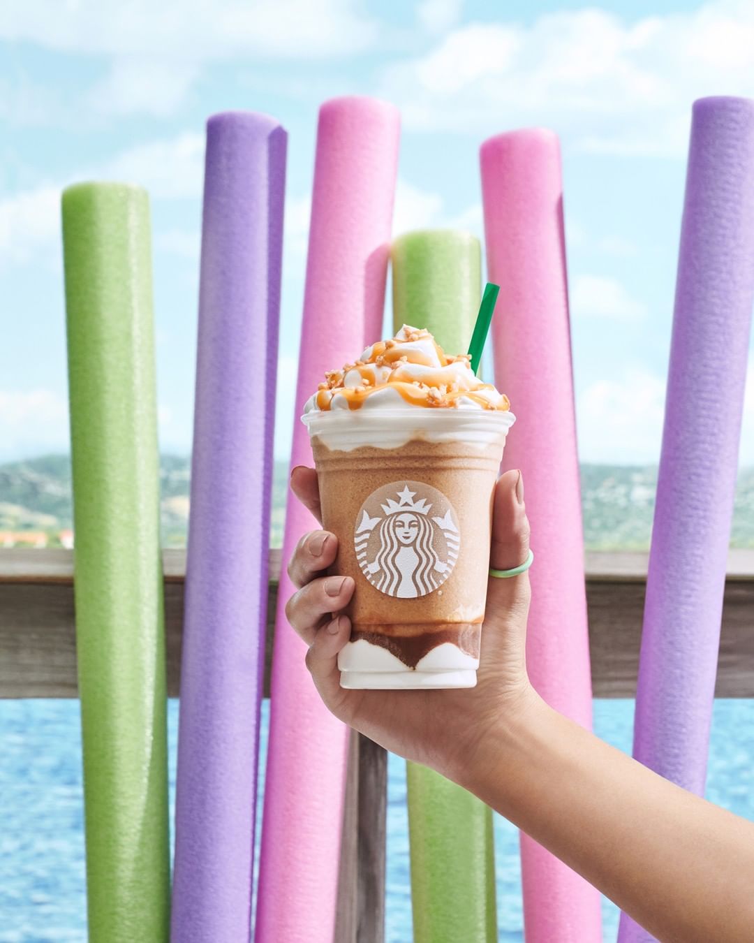 hand holding cup of starbucks caramel ribbon crunch frappucino