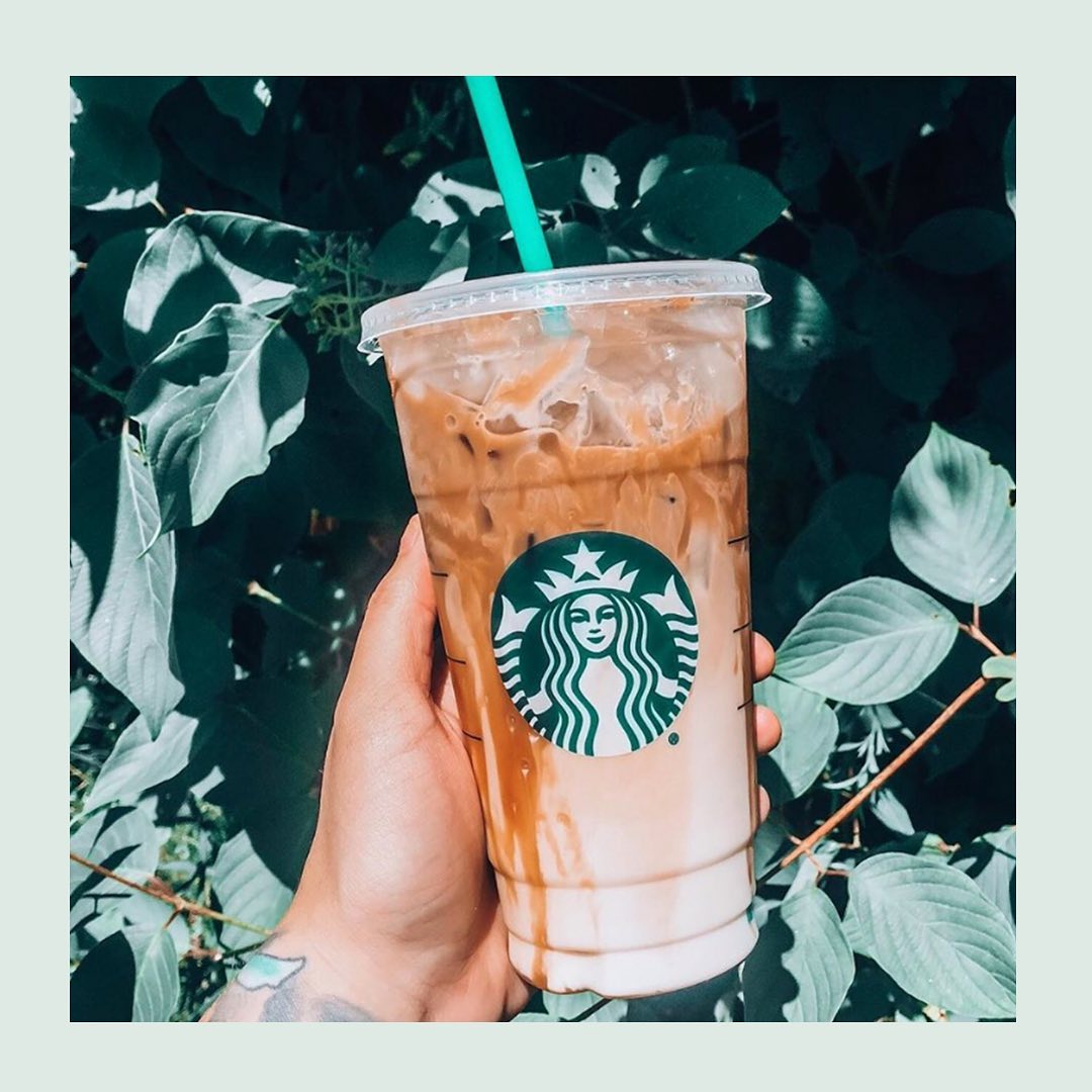 hand holding cup of starbucks iced caramel machiato